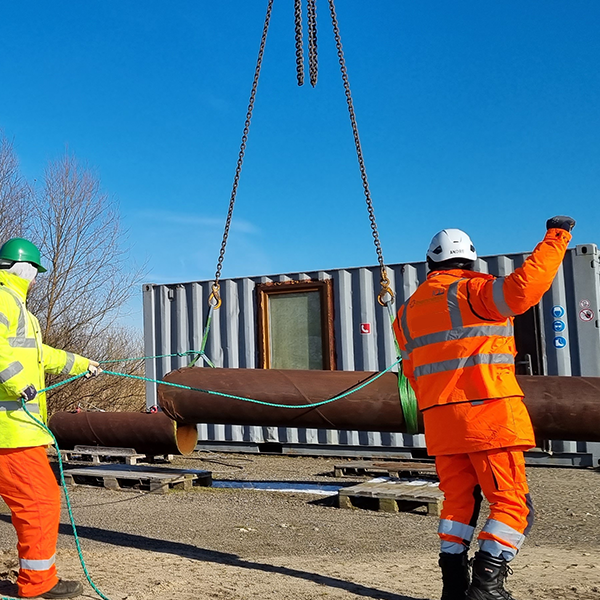 2 people slinging and signalling a load for a mobile crane