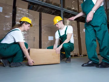 manual handling training instructor showing people how to lift a box with correct lifting techniques